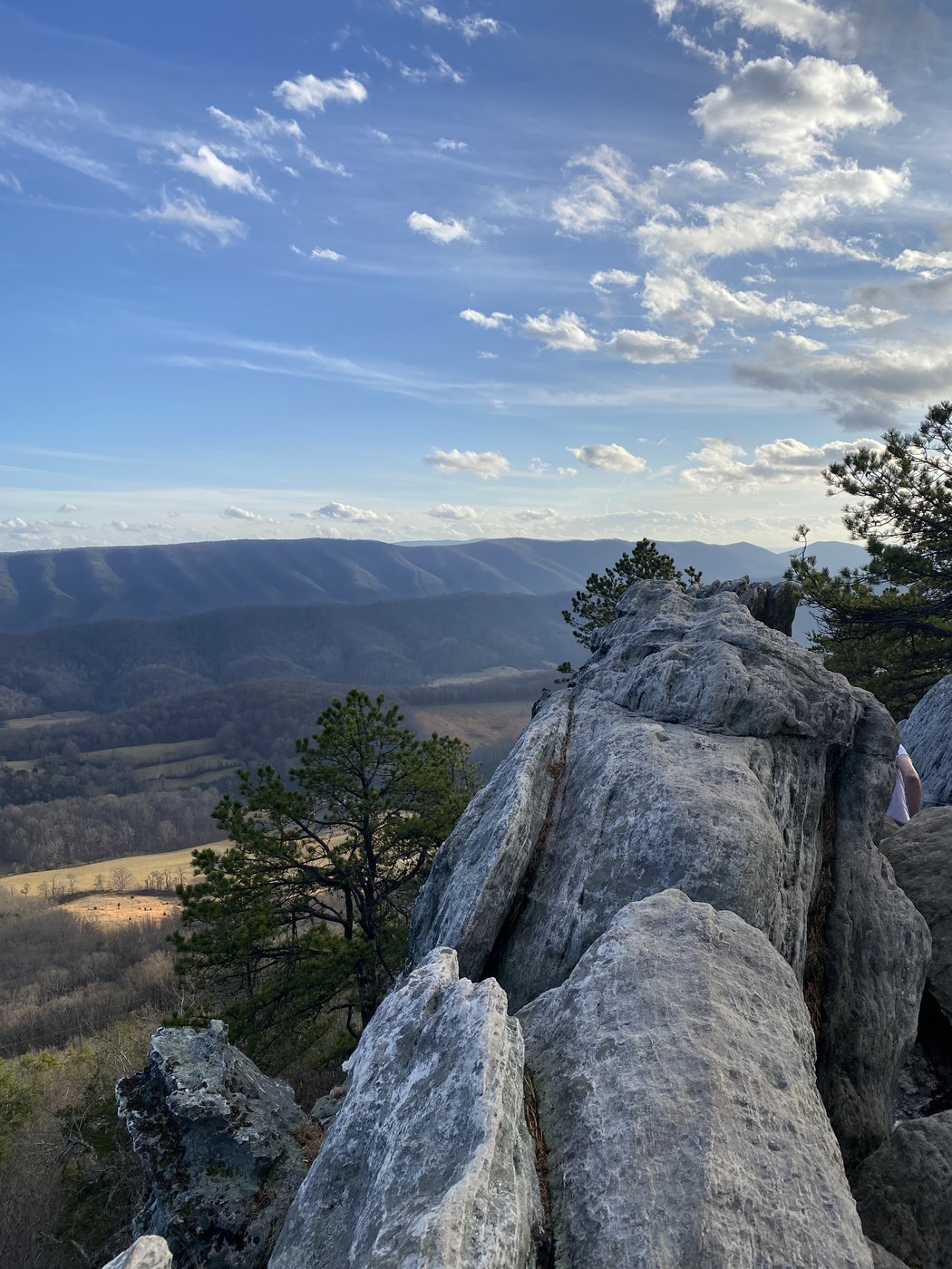 A jagged rock outcrop rising above a valley under a blue sky