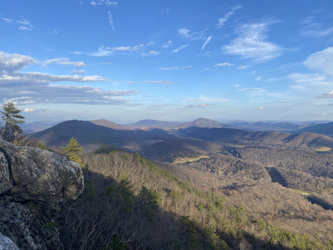 Rock outcrop and rolling blue ridges under a clear sky
