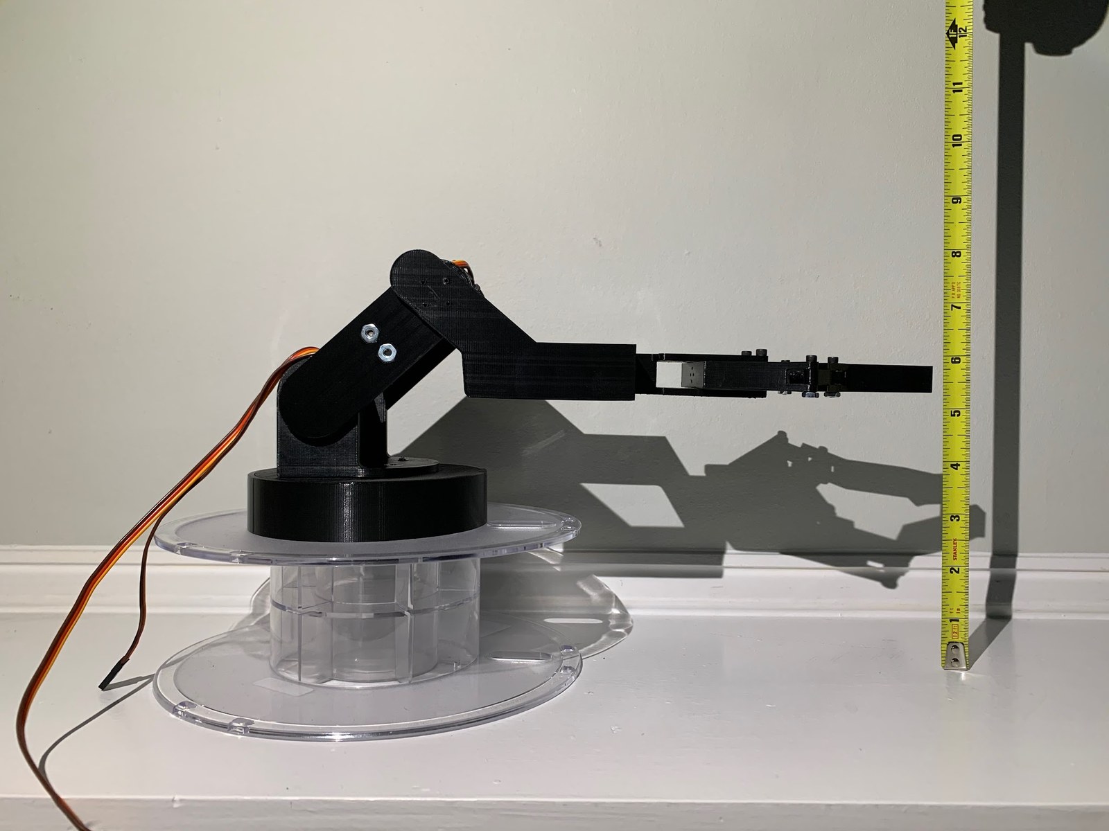 The arm photographed against a vertical tape measure showing its height